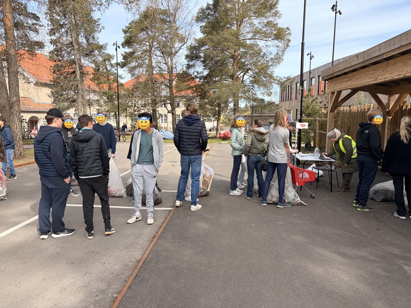 Elever står i kø for å veie søppel de har plukket mens de plogget