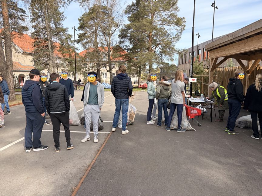 Elever står i kø for å veie søppel de har plukket mens de plogget